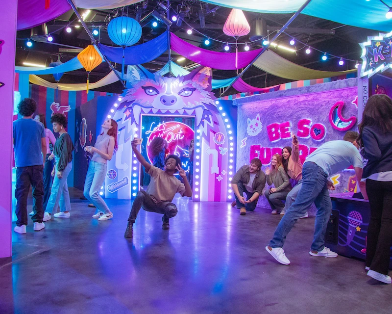 Groups of friends hang out in the themed Wednesday carnival, taking photos with the iconic sets.