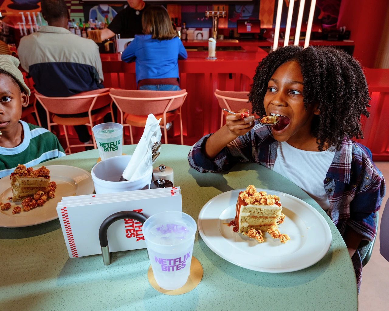 A child eats the Netflix House cake at Netflix Bites.