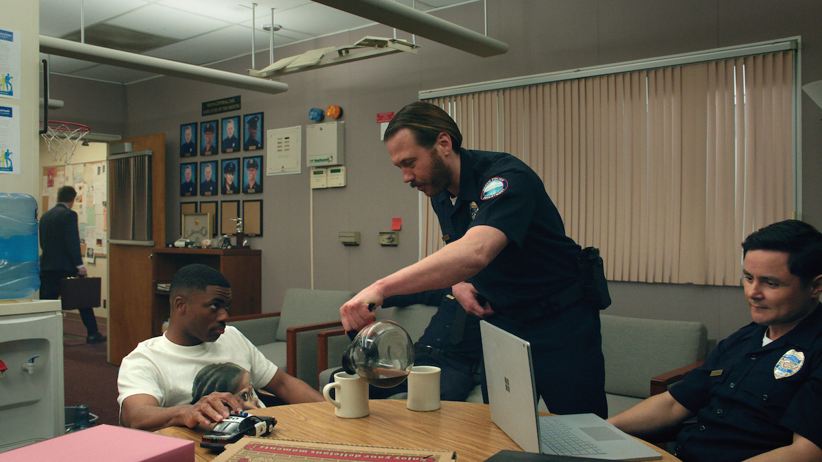 Vince Staples as Vince Staples sits in a police station with Scott MacArthur as Officer Boucher, and Arturo Castro as Officer Gutierrez in season 1 of ‘The Vince Staples Show’