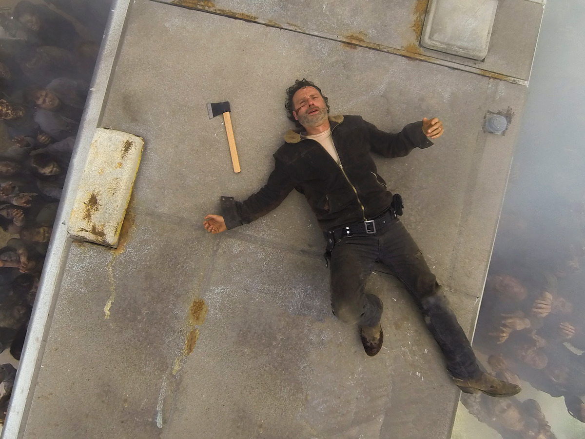 Rick laying on his back looking beat up and defeated. 