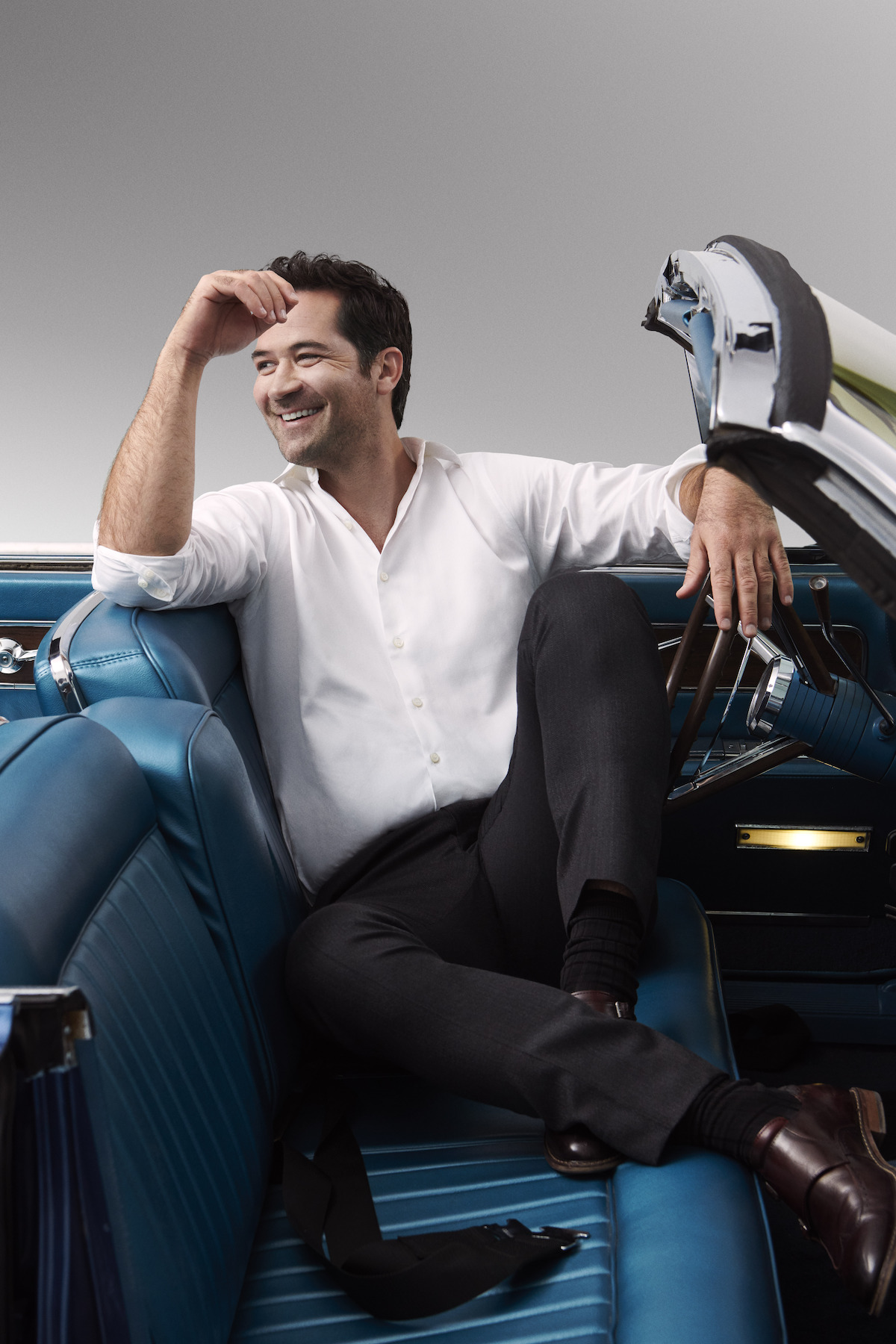 Manuel Garcia-Rulfo sits in blue sports car.