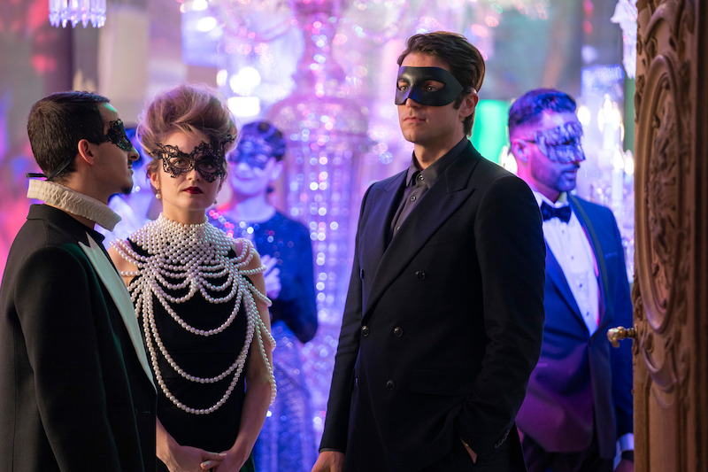 Lucas Bravo, como Gabriel, usa uma máscara em uma festa na temporada 4 de ‘Emily em Paris’