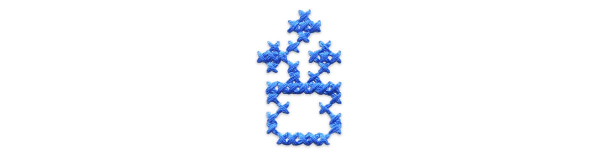 Blue cross stitched vase of flowers.