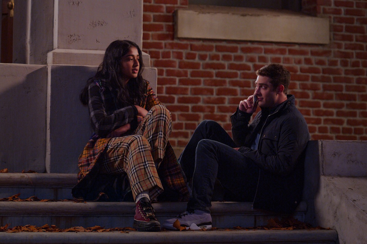 Maitreyi Ramakrishnan as Devi and Jaren Lewison as Ben Gross in Never Have I Ever Season 4 sitting on steps outside Princeton.