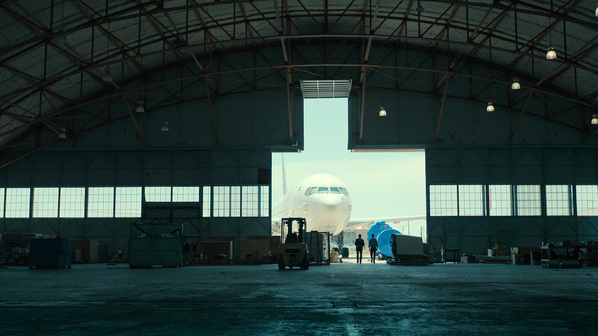 Donald Schmitt and Kevin Randle in an airplane hangar.