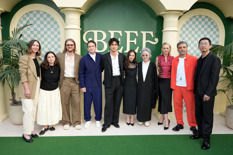 Group of people standing together in front of a green backdrop with the word "BEEF," flanked by columns, plants, and decorative arches, wearing formal and semi-formal outfits, at what appears to be an event or gathering.