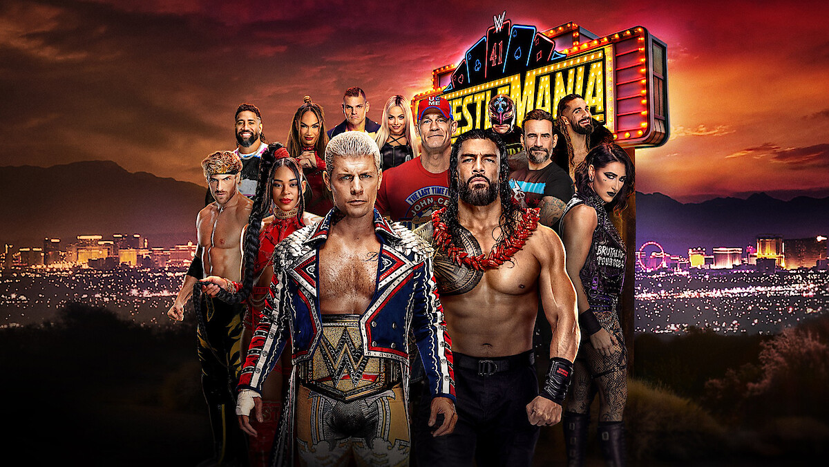 WWE wrestlers standing in front of a WrestleMania neon sign.