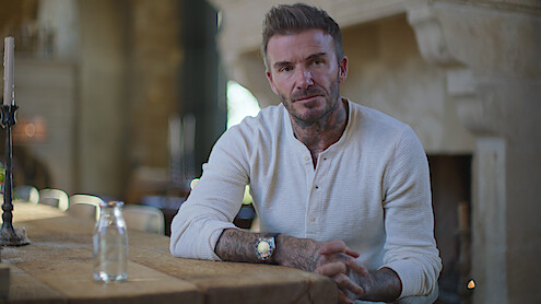 David Beckham sits at a table.