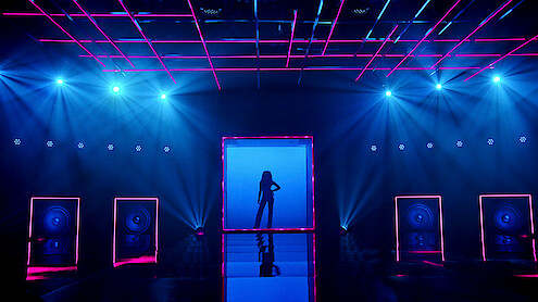 A silhouetted figure enters the stage.