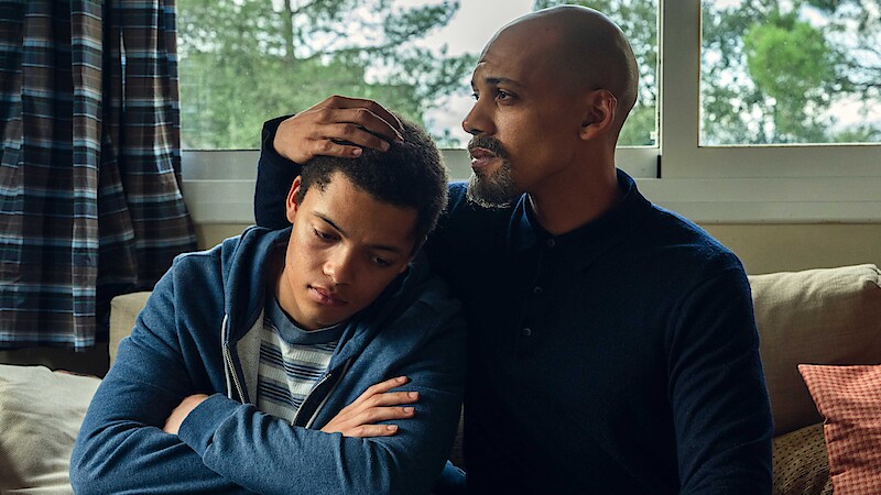 A father and son share a moment together while seated. 