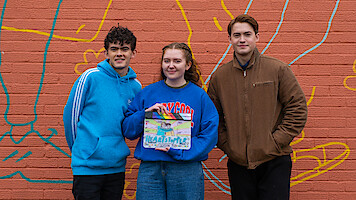 Joe Locke, Alice Oseman e Kit Connor posam juntos com uma claquete da temporada 3 de Heartstopper.